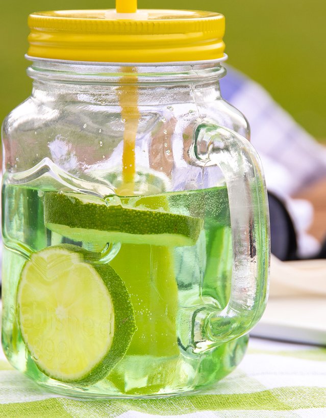 Das Bild zeigt einen Pfeffi Cocktail mit Strohhalm und Limettenscheiben 