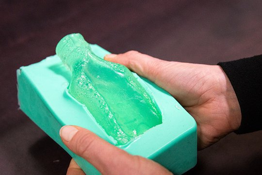 Man sieht, wie die fertige Pfeffi Seife aus der Seifenform gedrückt wird