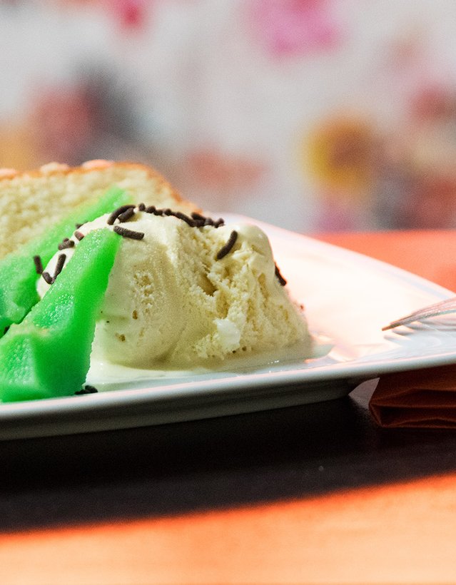 Das Bild zeigt eine grüne Birne nebst Vanilleeis und einem Stück Kuchen