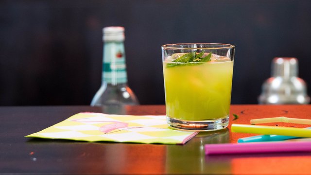 Das Bild zeigt einen grünen Cocktail, der auf einer Theke steht