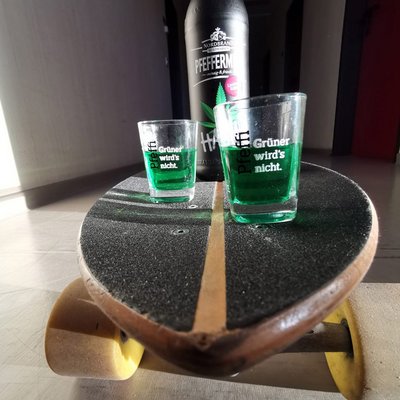 Hanpf Fanbild 5 Das Bild zeigt zwei Pfeffi Pinnchen auf einem Skateboard, dahinter ist die Hanpf Fasche zu erkennen