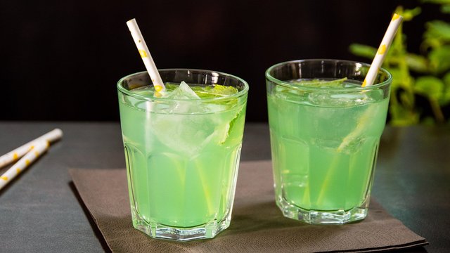 Das Bild zeigt einen hellgrünen Cocktail auf einer Serviette
