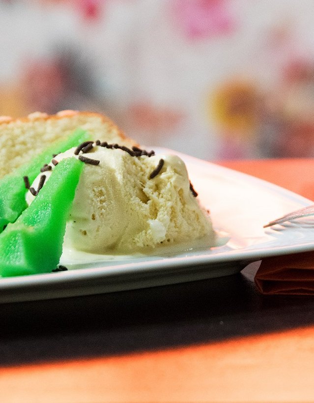 Das Bild zeigt eine grüne Birne nebst Vanilleeis und einem Stück Kuchen