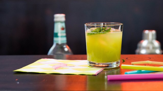 Das Bild zeigt einen grünen Cocktail, der auf einer Theke steht