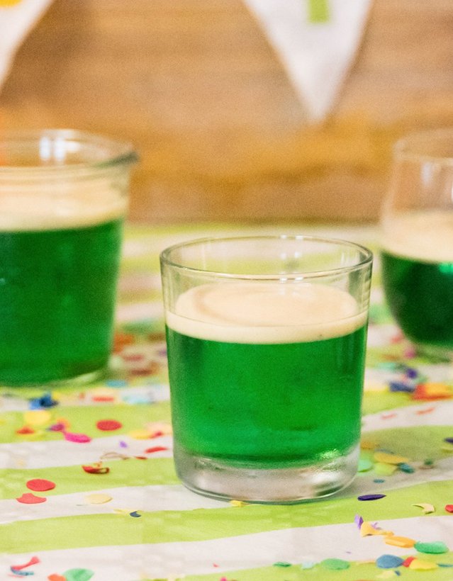 Pfeffi Rezept Wackelpfeffi Das Bild zeigt 4 Gläser mit grünem Inhalt und Luftballons im Hintergrund