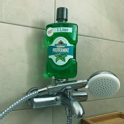 Mundwasser Fanbild 7 Das Bild zeigt eine Mundwasser Flasche auf einer Duschbrause.