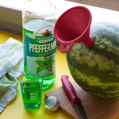 Pfeffi Rezept Pfeffi Melone Zutaten Man sieht eine Melone, in die ein Trichter gesteckt wurde nebst Pfeffi Flasche