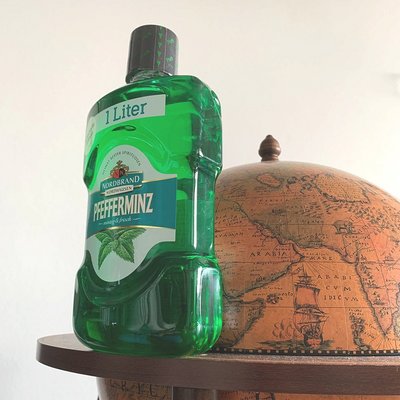 Mundwasser Fanbild 5 Das Bild zeigt eine Mundwasser Flasche neben einem Globus
