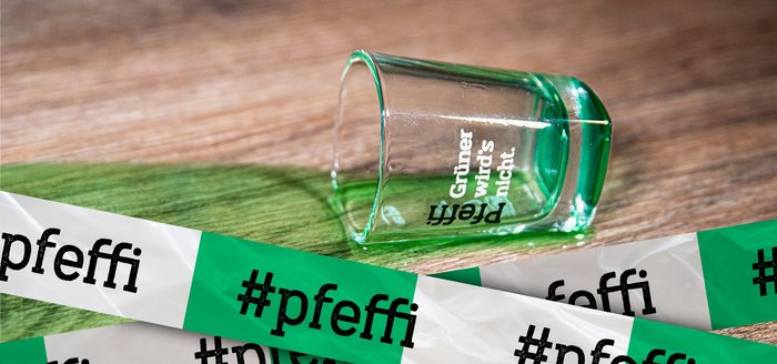 Das Bild zeigt ein Pfeffi Pinnchen, das umgefallen ist. Davor sieht man grün-weißes Absperrband mit der Aufschrift "#pfeffi".