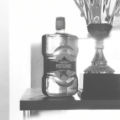 Mundwasser Fanbild 4 Das Bild ist in schwarz/weiß gehalten. Es zeigt eine Mundwasser Flasche neben einem Pokal.