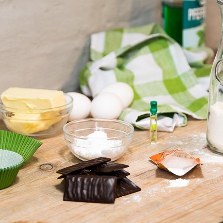 Das Bild zeigt allle Zutaten für die Grünen Giftzwerge: Eier, Mehl, Schokolade und Pfeffi