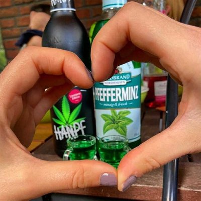 Hanpf Fanbild 8 Das Bild zeigt zwei Hände, die ein Herz formen. Dahinter erkennt man eine Hanpf und eine "normale" Pfeffi Flasche.