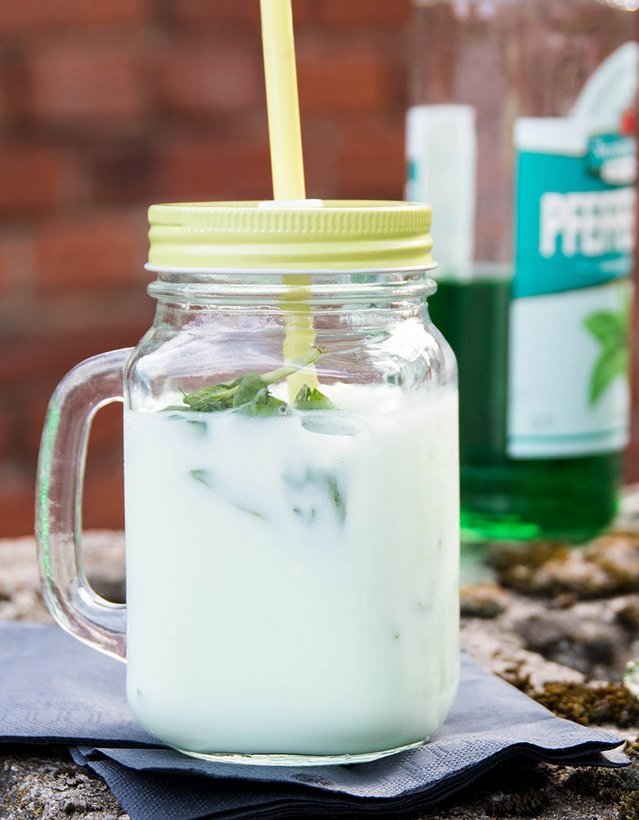 Pfeffi Rezept Milchbubi Das Bild zeigt einen milchig-grünen Cocktail auf einer Mauer