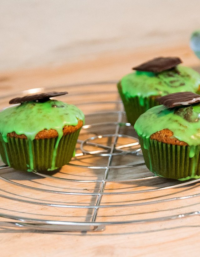 Das Bild zeigt drei Muffins mit grüner Glasur