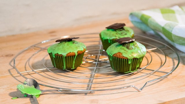 Das Bild zeigt drei Muffins mit grüner Glasur